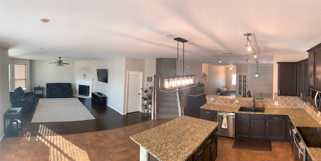 9140 Blackstone Dr, Providence Village, TX 76227 - kitchen featuring ceiling fan, a peninsula, dark brown cabinets, a sink, and stainless steel appliances