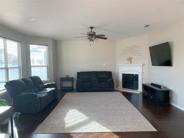 9140 Blackstone Dr, Providence Village, TX 76227 - living room featuring visible vents, baseboards, ceiling fan, dark wood-type flooring, and a glass covered fireplace