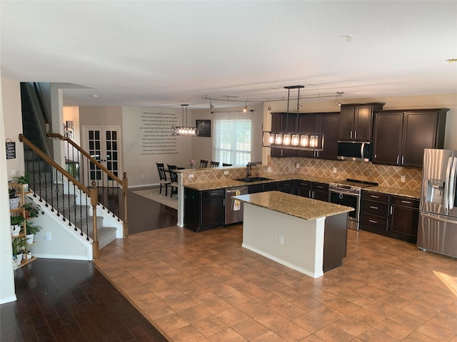 9140 Blackstone Dr, Providence Village, TX 76227 - kitchen with stainless steel appliances, a sink, backsplash, and a kitchen island