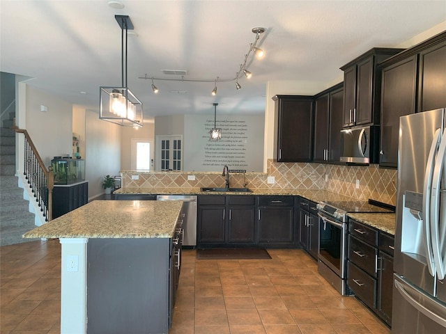 9140 Blackstone Dr, Providence Village, TX 76227 - kitchen featuring tasteful backsplash, light stone countertops, visible vents, appliances with stainless steel finishes, and a sink