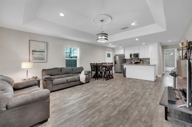 530 E Day St, Denison, TX 75021 - living room featuring visible vents, a tray ceiling, recessed lighting, light wood finished floors, and attic access