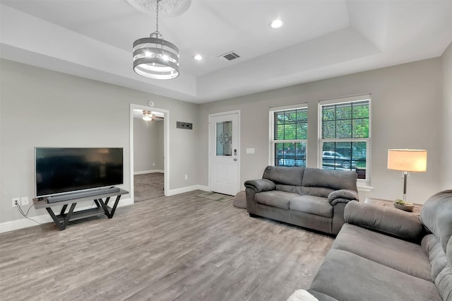 530 E Day St, Denison, TX 75021 - living room featuring visible vents, wood finished floors, a raised ceiling, baseboards, and a notable chandelier