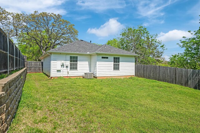 530 E Day St, Denison, TX 75021 - back of house with roof with shingles, a fenced backyard, central AC unit, and a lawn