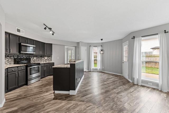 322 Ashley Oak Ln, Lake Dallas, TX 75065 - kitchen featuring tasteful backsplash, a wealth of natural light, visible vents, appliances with stainless steel finishes, and wood finished floors
