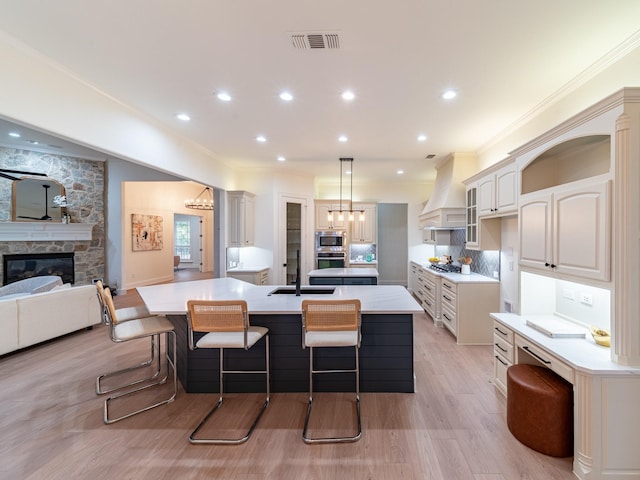 5454 Pebble Creek Dr, Celina, TX 75078 - kitchen with custom range hood, a breakfast bar, visible vents, and a spacious island