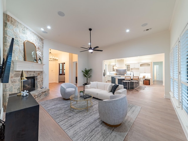 5454 Pebble Creek Dr, Celina, TX 75078 - living room with a fireplace, light wood-style flooring, ornamental molding, and ceiling fan