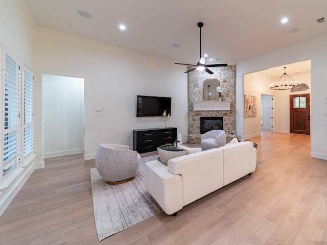 5454 Pebble Creek Dr, Celina, TX 75078 - living room with light wood finished floors, a stone fireplace, ceiling fan with notable chandelier, and ornamental molding