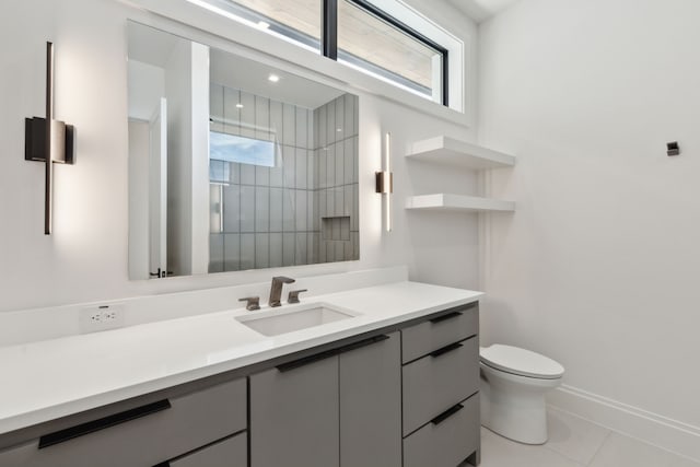 bathroom featuring toilet, tiled shower, tile patterned floors, baseboards, and vanity