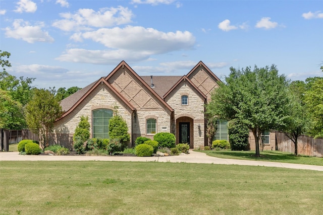 7217 Deer Field Dr, Mansfield, TX 76063 - french country style house with stone siding, a front yard, and fence