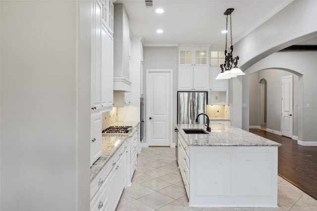7217 Deer Field Dr, Mansfield, TX 76063 - kitchen with a sink, decorative backsplash, glass insert cabinets, arched walkways, and stainless steel appliances