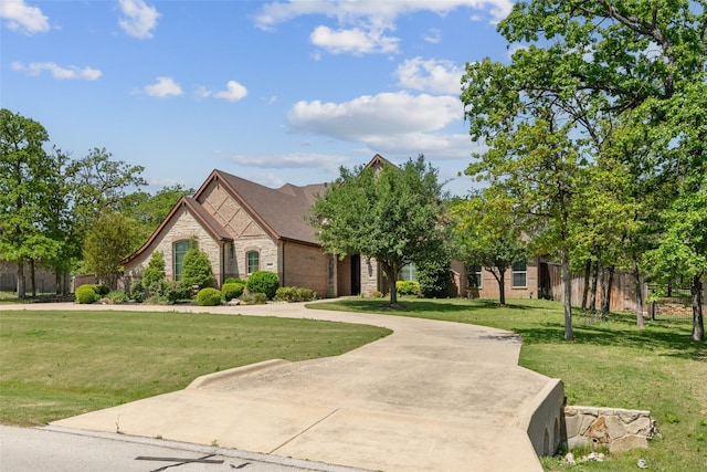 7217 Deer Field Dr, Mansfield, TX 76063 - view of front facade featuring fence, curved driveway, a front yard, and stone siding