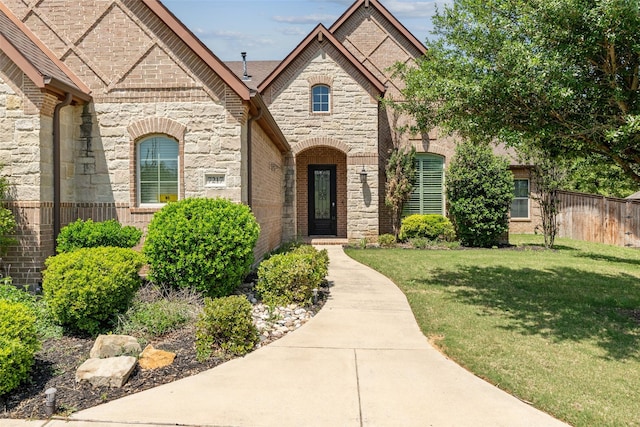 7217 Deer Field Dr, Mansfield, TX 76063 - french country style house with stone siding, a front yard, and fence