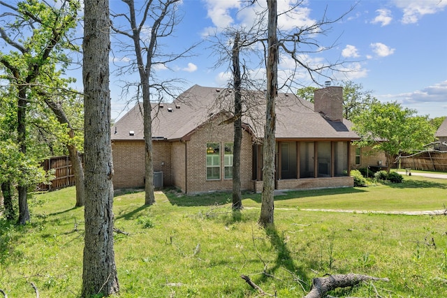 7217 Deer Field Dr, Mansfield, TX 76063 - rear view of property featuring central air condition unit, a chimney, fence, a yard, and brick siding