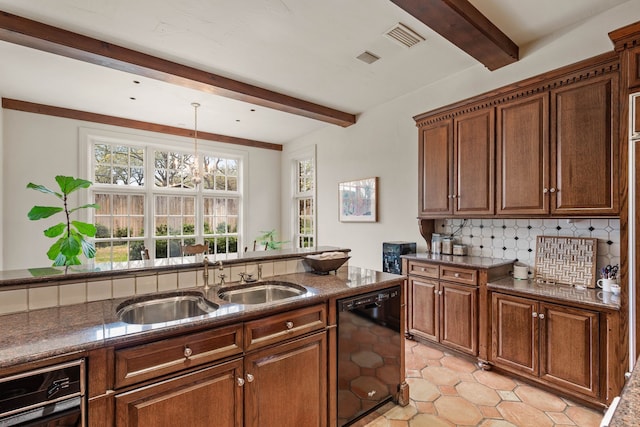 kitchen featuring tasteful backsplash, black dishwasher, a sink, beam ceiling, and dark stone counters