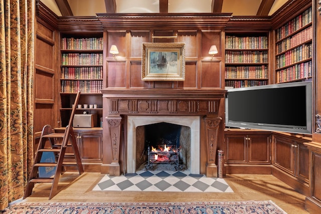 living area featuring a fireplace with flush hearth and built in features