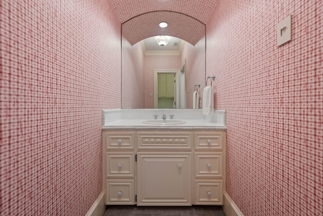bathroom featuring crown molding, baseboards, and vanity