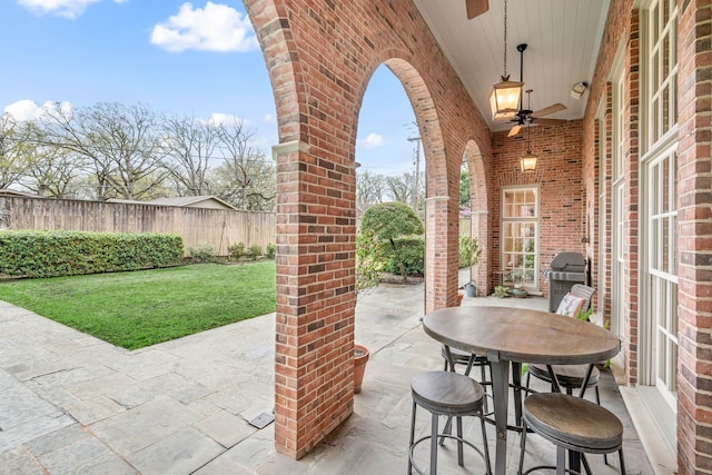 view of patio / terrace with grilling area, ceiling fan, and fence
