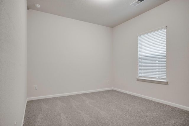 carpeted spare room with baseboards and visible vents