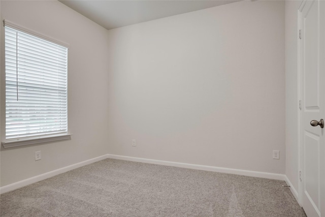 carpeted spare room featuring baseboards