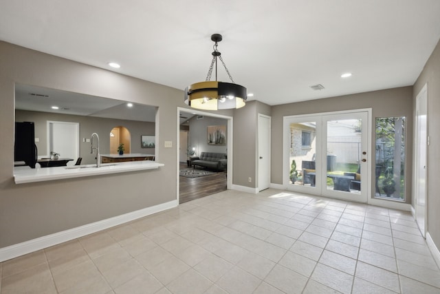 unfurnished dining area with tile patterned flooring, visible vents, recessed lighting, a sink, and baseboards
