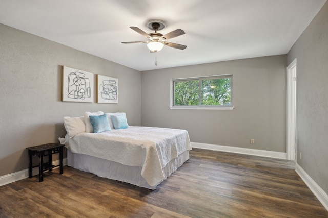 bedroom featuring baseboards, ceiling fan, and dark wood-style floors