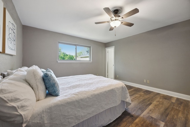 bedroom featuring baseboards, ceiling fan, and dark wood finished floors
