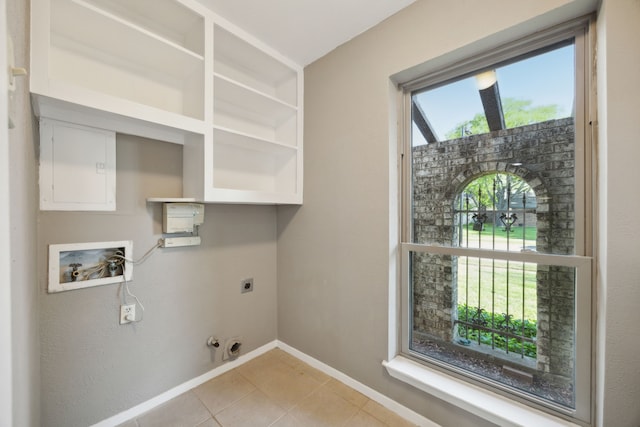 clothes washing area featuring baseboards, laundry area, electric dryer hookup, hookup for a washing machine, and light tile patterned flooring