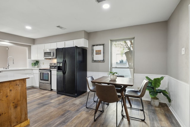kitchen featuring light countertops, white cabinets, visible vents, stainless steel appliances, and a sink