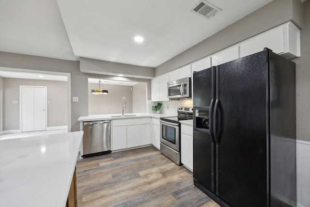 kitchen featuring visible vents, a sink, light countertops, appliances with stainless steel finishes, and white cabinetry