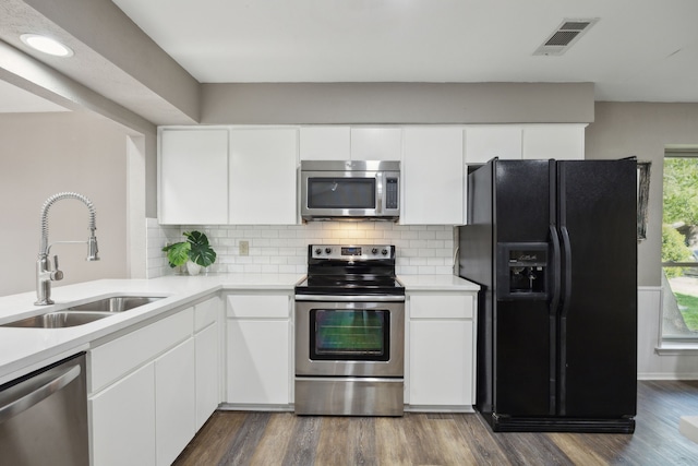 kitchen featuring light countertops, visible vents, decorative backsplash, stainless steel appliances, and a sink
