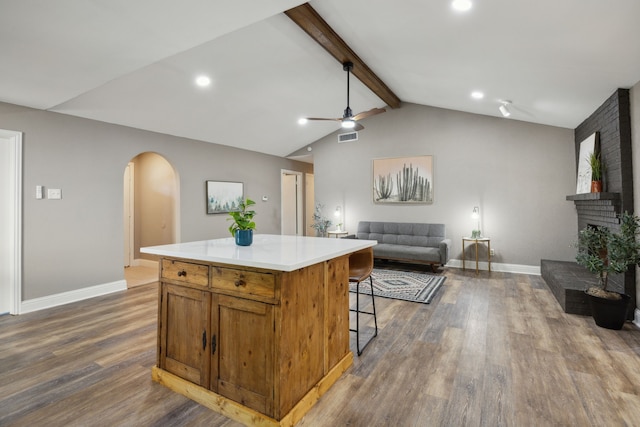 kitchen with open floor plan, a ceiling fan, visible vents, arched walkways, and wood finished floors