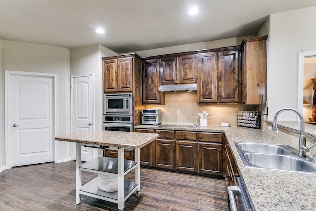 701 Ireland Way, Wylie, TX 75098 - kitchen with under cabinet range hood, dark wood-style flooring, baseboards, and appliances with stainless steel finishes