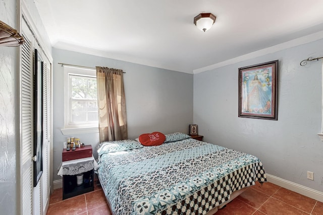 bedroom with baseboards and tile patterned flooring