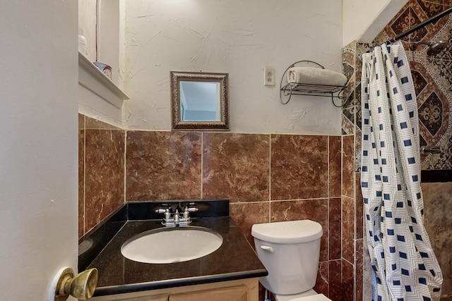 bathroom with toilet, vanity, curtained shower, and tile walls