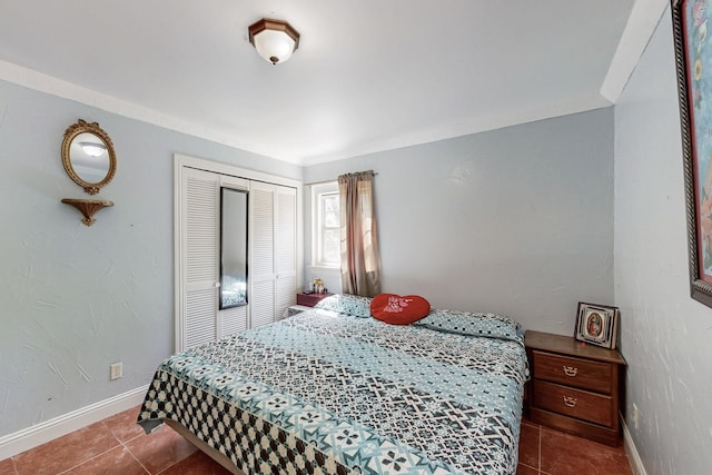 tiled bedroom with baseboards and a closet