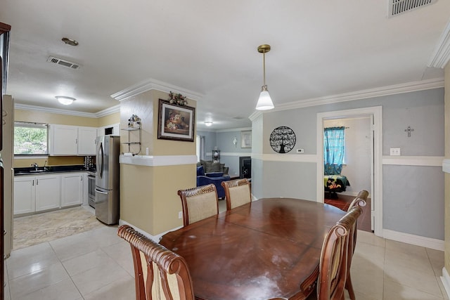 dining space featuring visible vents, crown molding, and light tile patterned floors