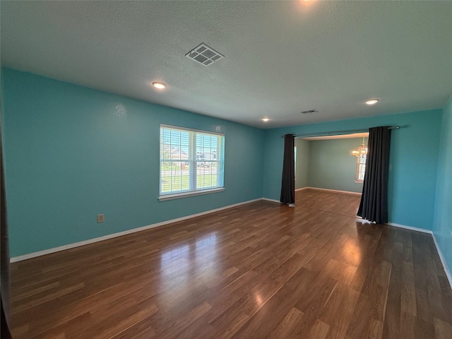 100 Russell St, Lorena, TX 76655 - unfurnished room featuring dark wood finished floors, a chandelier, a textured ceiling, baseboards, and recessed lighting