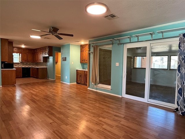 100 Russell St, Lorena, TX 76655 - unfurnished living room featuring a ceiling fan, wood finished floors, healthy amount of natural light, and baseboards