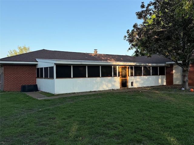 100 Russell St, Lorena, TX 76655 - back of property featuring a sunroom, a yard, brick siding, and a shingled roof