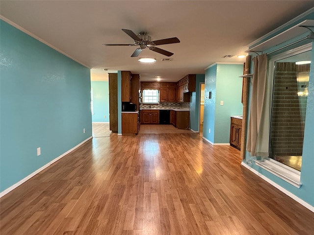 100 Russell St, Lorena, TX 76655 - kitchen with ceiling fan, light wood finished floors, light countertops, crown molding, and baseboards