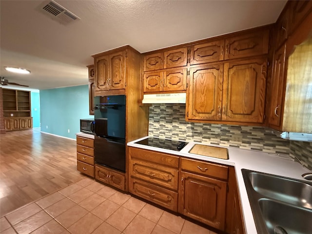 100 Russell St, Lorena, TX 76655 - kitchen with black appliances, a sink, tasteful backsplash, brown cabinetry, and light countertops