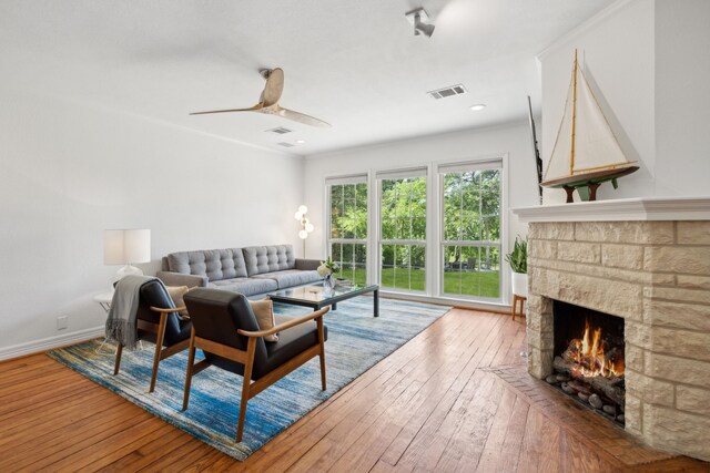 9431 Waterview Rd, Dallas, TX 75218 - living area featuring visible vents, baseboards, a stone fireplace, ceiling fan, and wood-type flooring