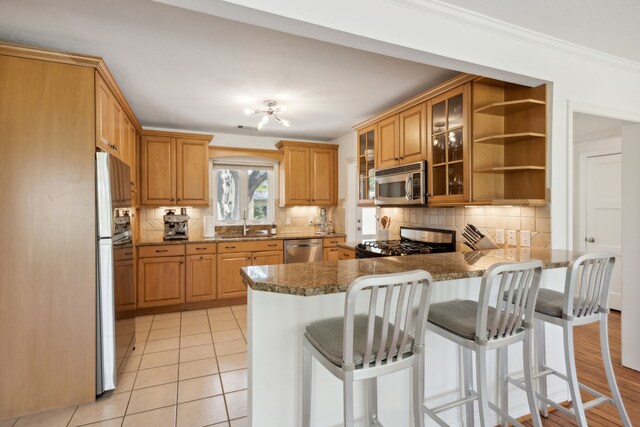 9431 Waterview Rd, Dallas, TX 75218 - kitchen featuring stainless steel appliances, tasteful backsplash, a peninsula, and glass insert cabinets