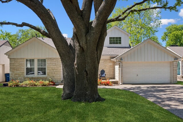 9431 Waterview Rd, Dallas, TX 75218 - view of front of property featuring a front yard, driveway, stone siding, and board and batten siding