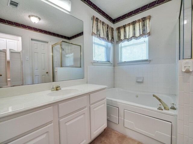 full bathroom with a bath, vanity, visible vents, and a stall shower
