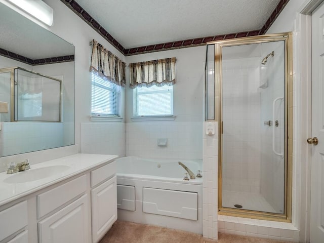bathroom featuring a stall shower, a textured ceiling, vanity, and a bath