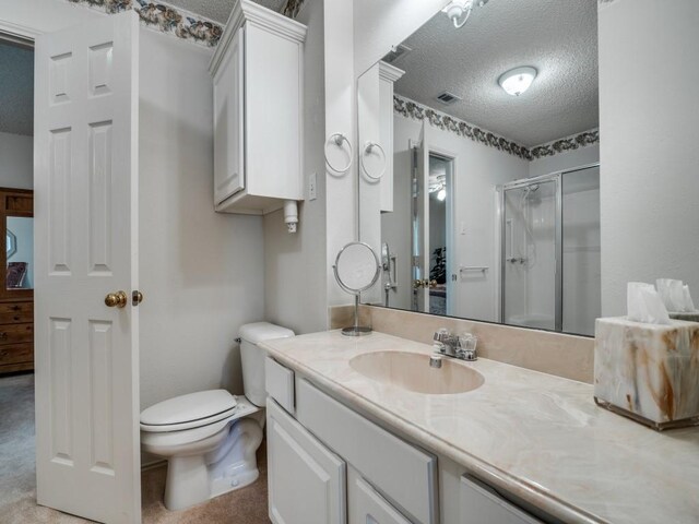 bathroom featuring toilet, vanity, a textured ceiling, visible vents, and a shower stall