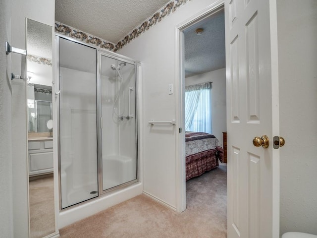 full bathroom featuring a stall shower, vanity, a textured ceiling, and connected bathroom