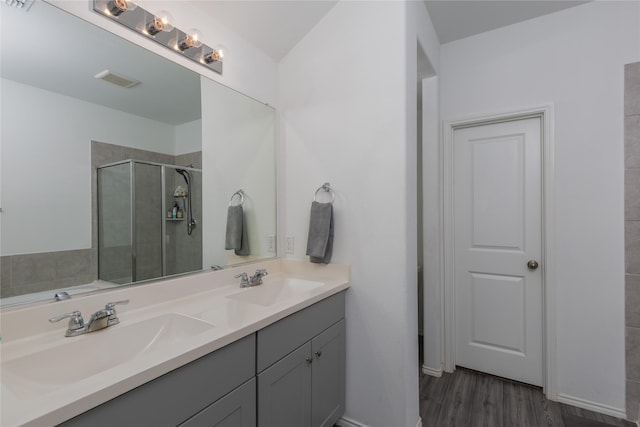 4512 Hiddenite Rd, Little Elm, TX 76227 - bathroom with double vanity, a shower stall, wood finished floors, and baseboards