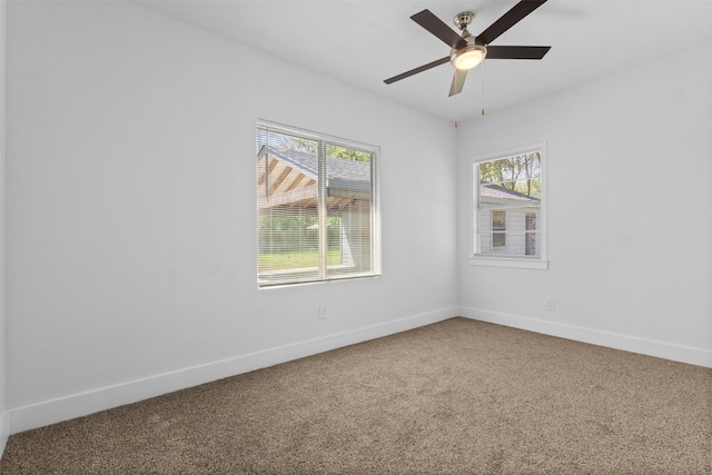 carpeted empty room featuring baseboards and ceiling fan